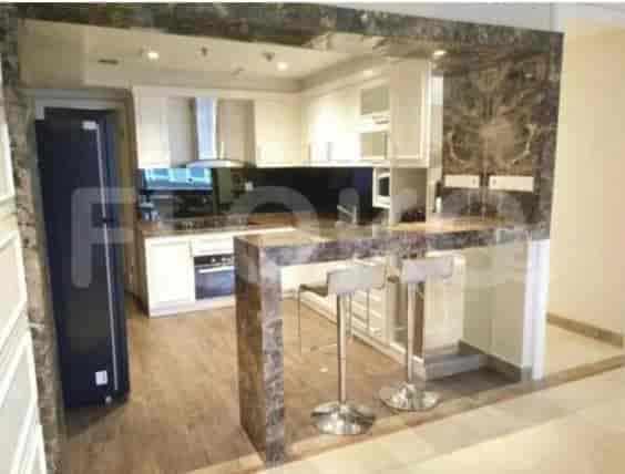 A modern kitchen with marble countertops, a breakfast bar, and built-in appliances.