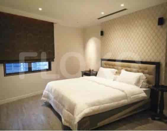 A well-lit bedroom with a queen-sized bed, neutral color scheme, and window with a blackout blind.