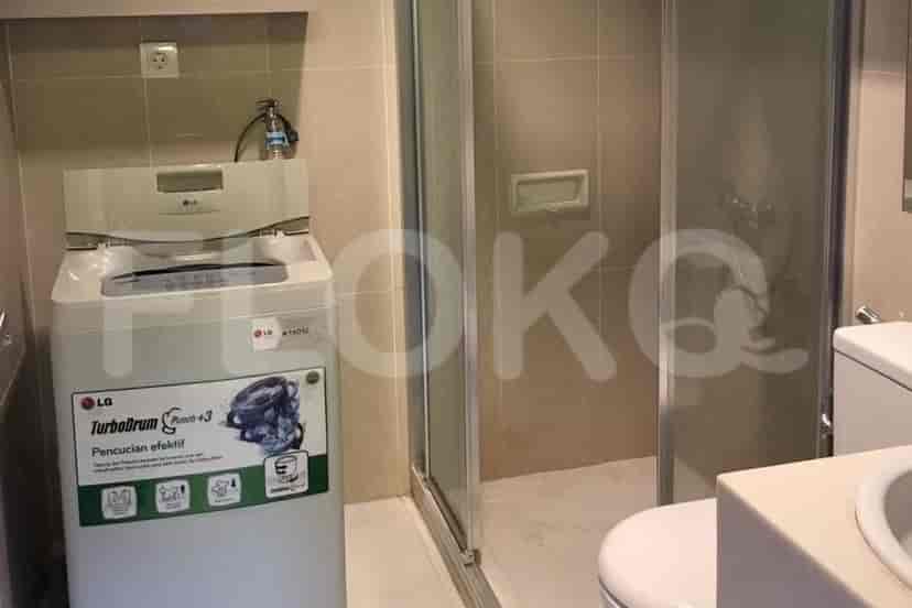 Bathroom with a washing machine and shower.