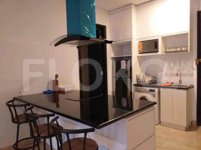 A contemporary kitchen with a black countertop, bar seating, and modern appliances.