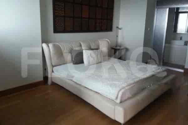 A bedroom with a bed and decorative wall hanging.