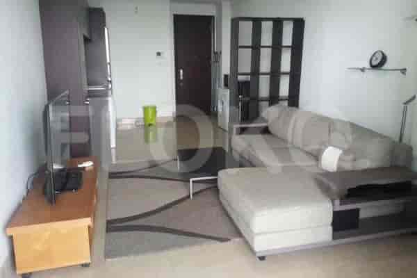 Modern living room with a grey sectional sofa, wooden TV stand, and access to a kitchen.