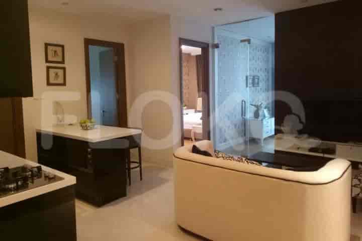 An open-plan living room and kitchen featuring a breakfast bar, sofa, and glass-doored entrance.