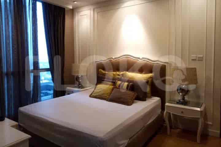 A spacious master bedroom with a large bed, bedside lamps, and elegant headboard.