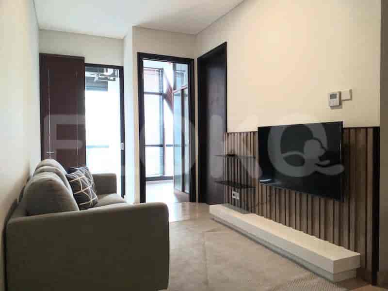 Modern living room with a sofa, TV, and entryways.