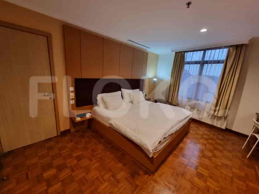 Spacious bedroom with a king-size bed and wood paneling.