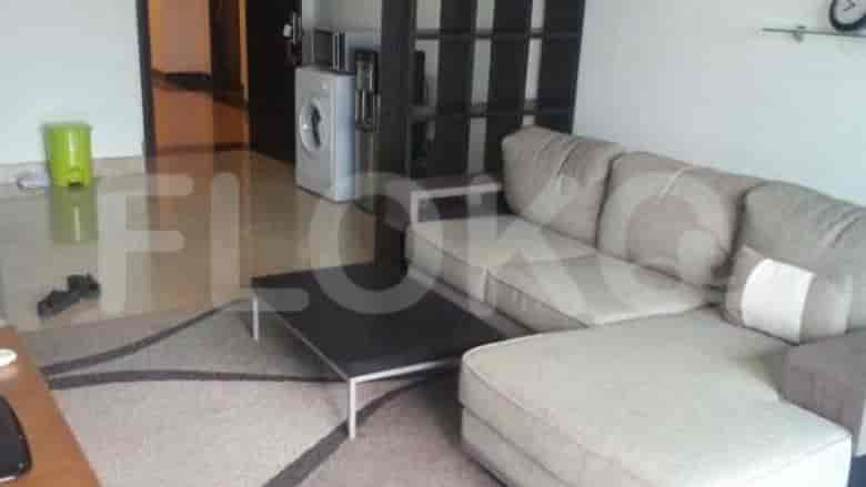 A living room with a beige L-shaped sofa, a black coffee table, and a view of the corridor and washer.