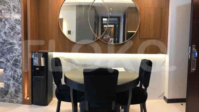 Dining area with a round black table, four chairs, and decorative mirrors.