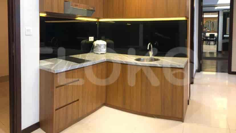 Modern kitchen with wooden cabinets, stone countertops, and a black glass backsplash.