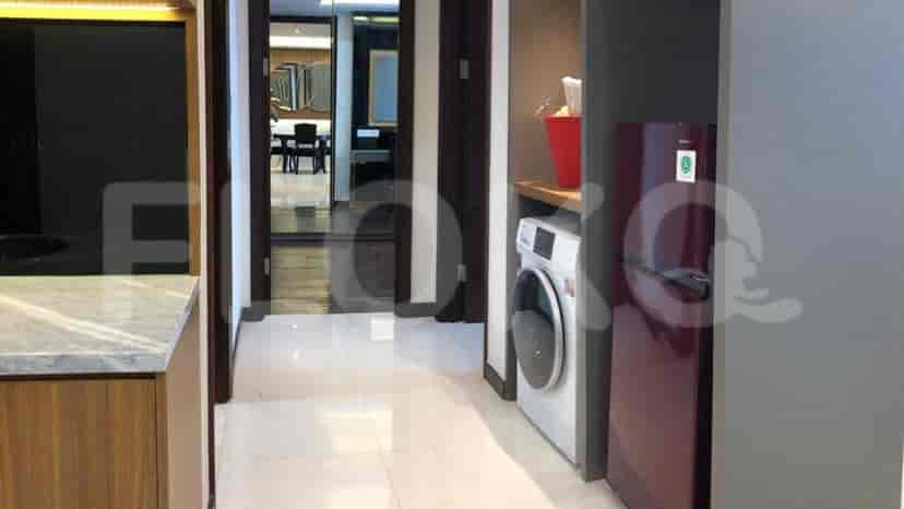 Entrance and utility room with a washing machine and refrigerator.
