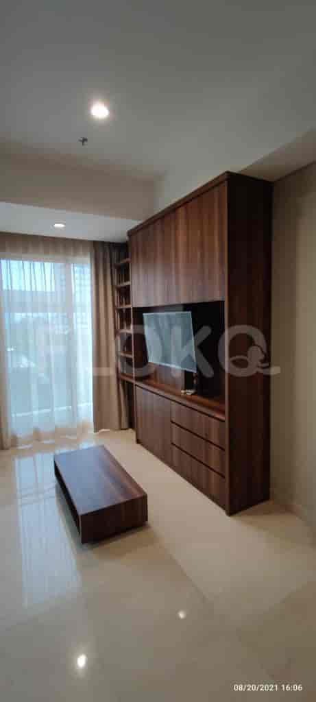Modern living room with built-in storage, TV, and a coffee table.