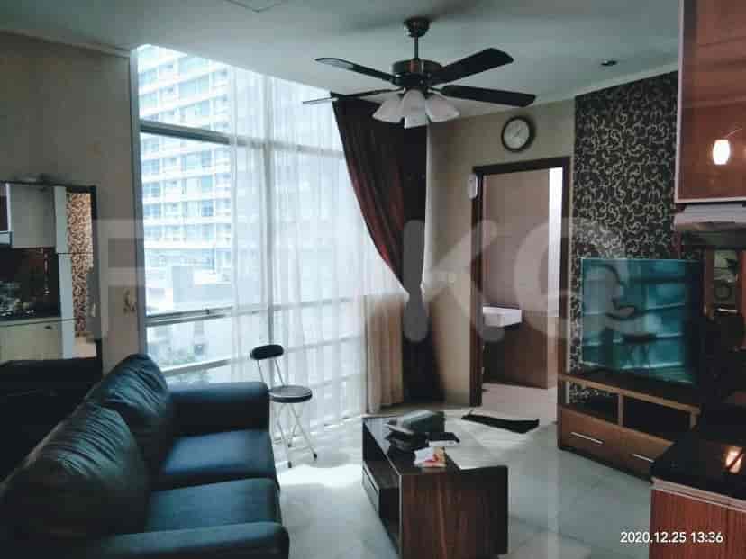 A living room with a view, a sofa, TV, and a ceiling fan.