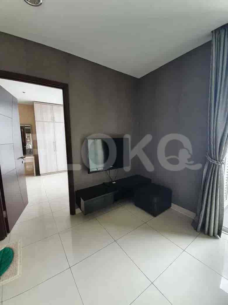 View of the living room with a TV and a door.