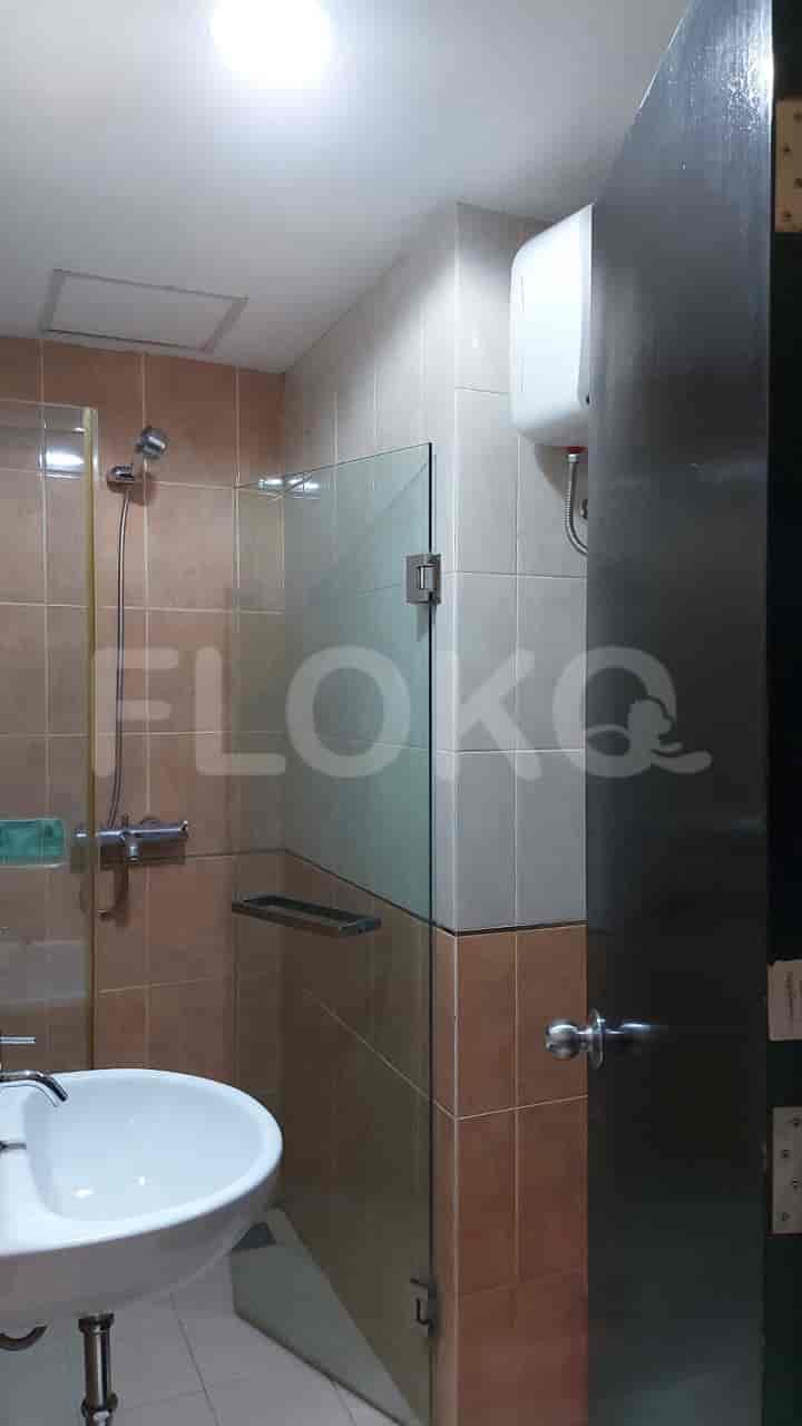 A modern bathroom featuring a glass shower enclosure, a sink, and tiled walls.
