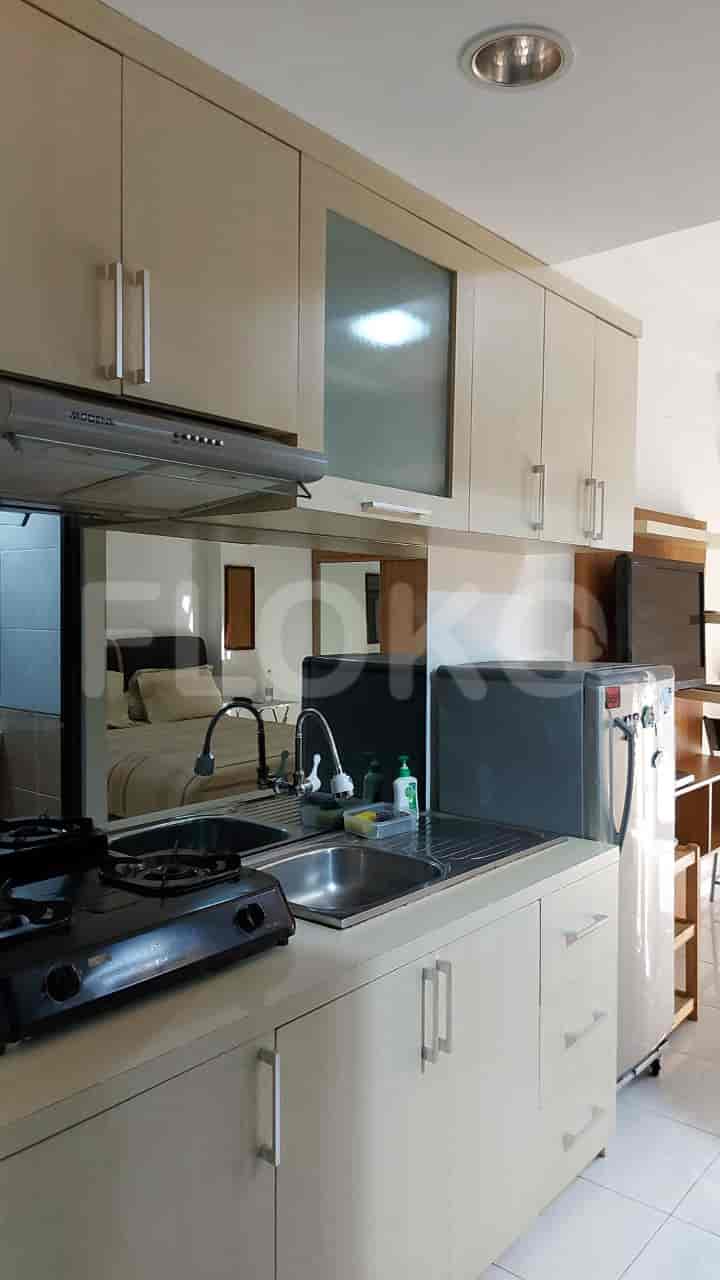 A modern kitchen with light-colored cabinets, a stainless steel sink, and a gas stove.
