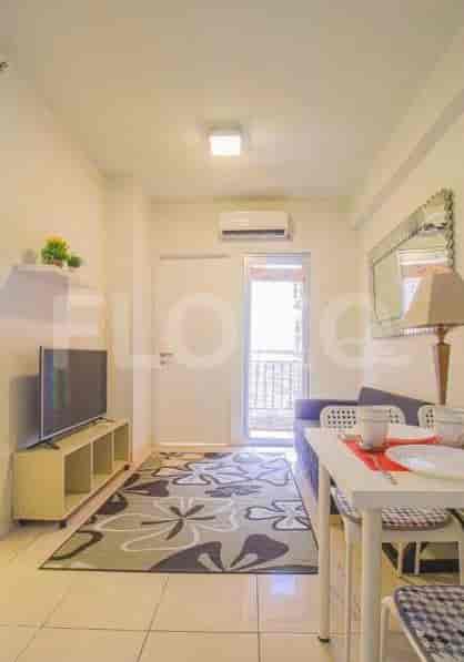Ruang tamu yang nyaman dengan TV, karpet, dan akses ke balkon.