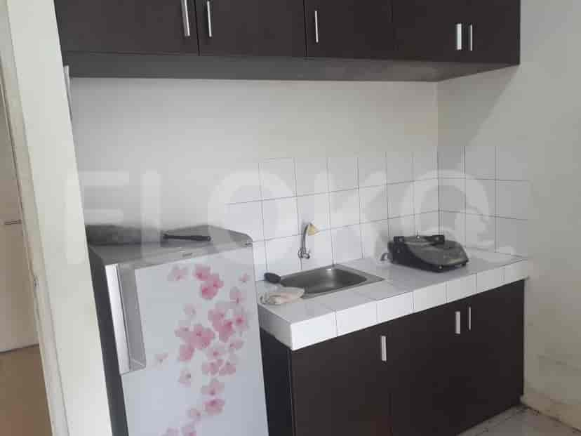 A small kitchen with a fridge and stove.