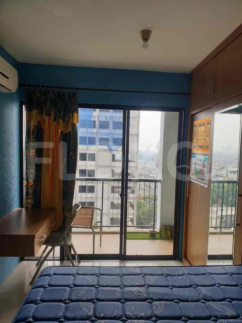 Bedroom with a view, desk, chair, and a balcony.