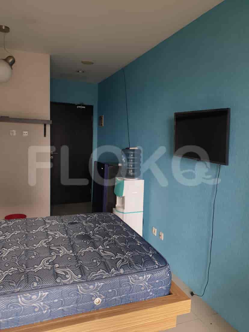 Bedroom with a bed, water dispenser, and TV.