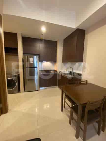 An open-plan kitchen featuring a refrigerator, cabinets, and dining table.