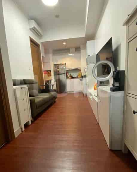Ruang tamu dengan sofa, TV, dan dapur terbuka.