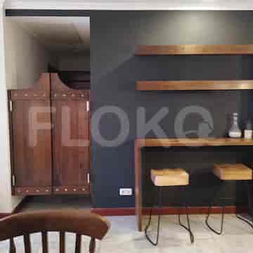 Breakfast bar with wooden stools, a dark wall, and shelving.