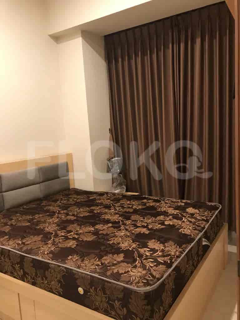 A cozy bedroom featuring a bed with a patterned mattress and dark curtains.