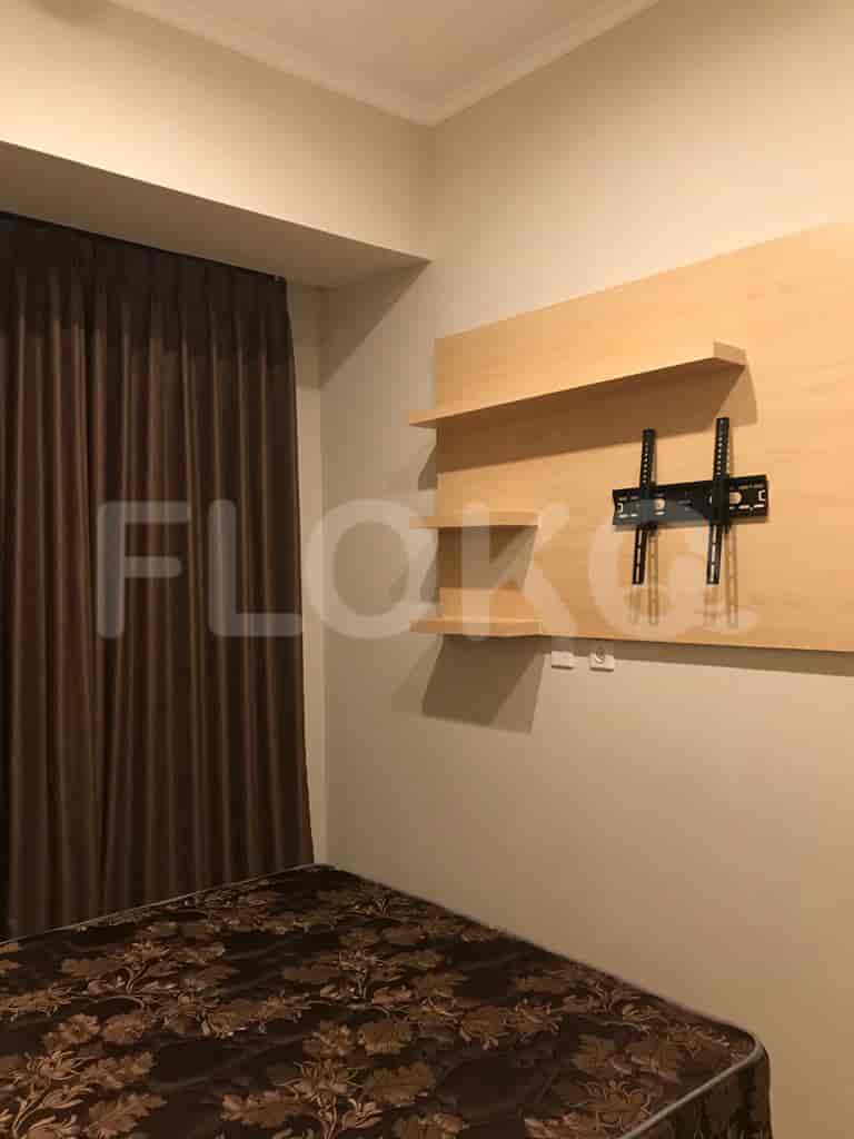 A modern bedroom with a bed and a wall-mounted entertainment unit.