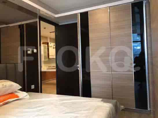 A bedroom featuring a bed with pillows, a large wardrobe, and a mirrored door.