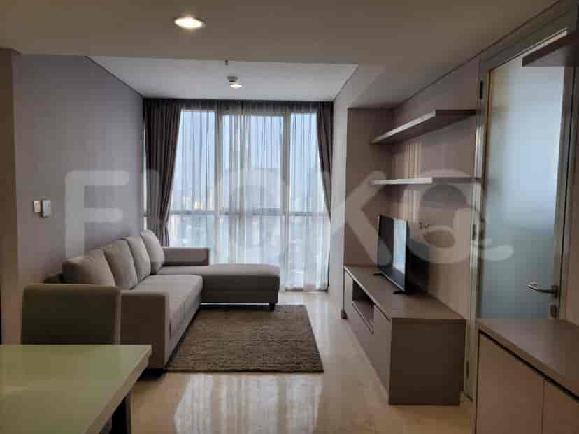 A living room with a grey sofa and a smart TV.