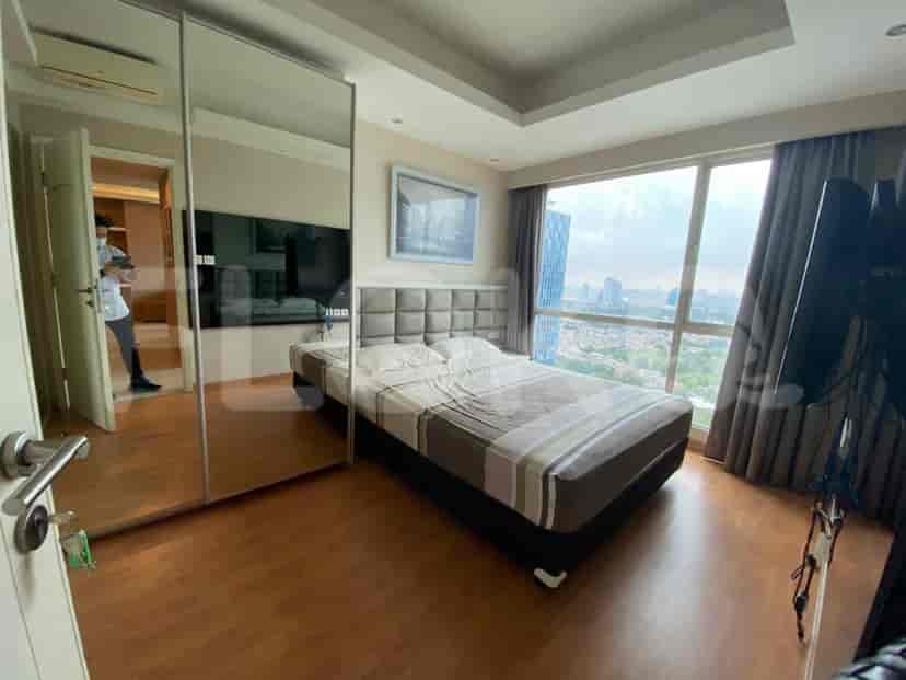A bedroom with a bed, mirror closet, and a window.