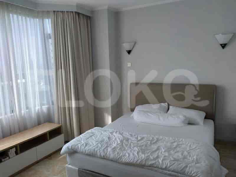 A bedroom with a double bed, curtains, and wall lamps.