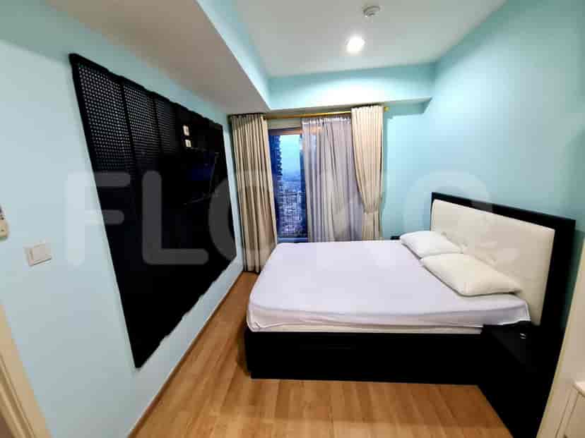 Bedroom with a bed, curtains, and light-colored walls.