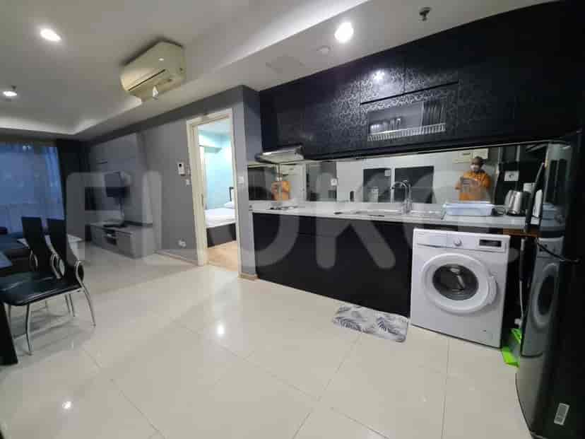 Contemporary kitchen with dark cabinetry, a washing machine, and light countertops.