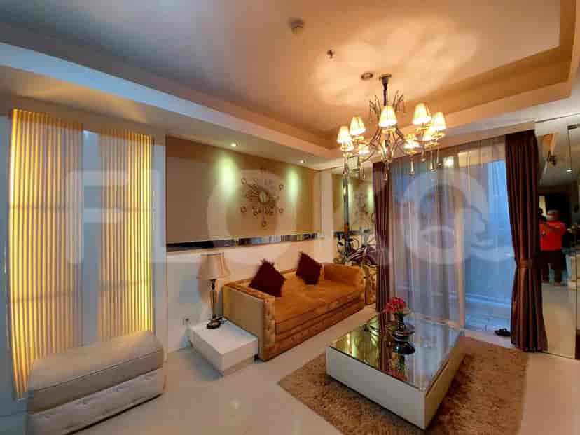 Living room with a sofa, chandelier, and mirrored accents.