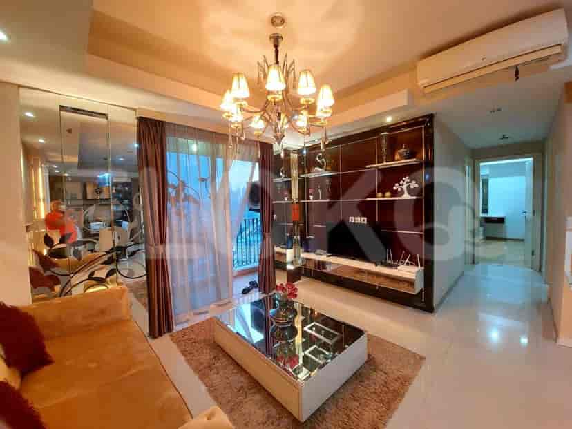 Living room with a chandelier, mirrored walls, and a glass coffee table.