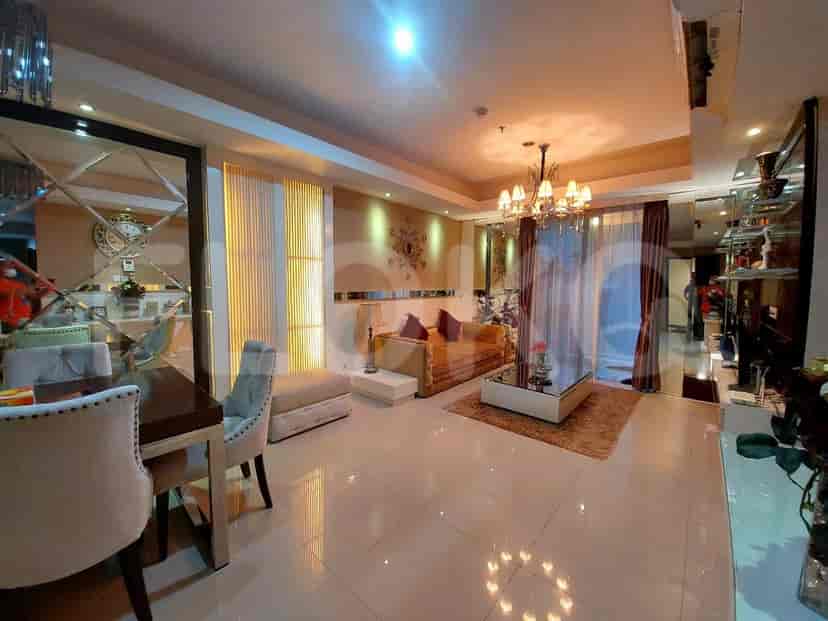 Living room featuring a sofa, mirrored walls, and a dining table.