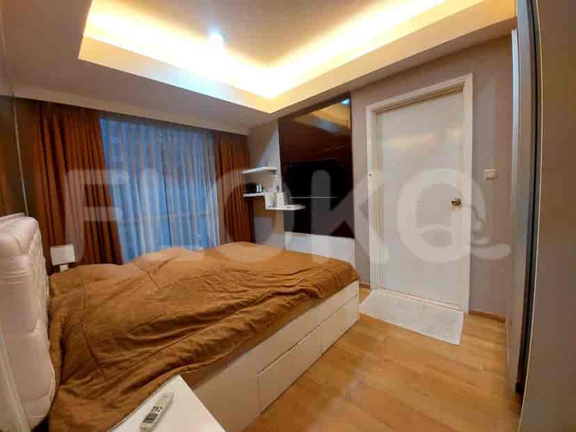 Bedroom with a large bed, dark orange curtains, and a white nightstand.