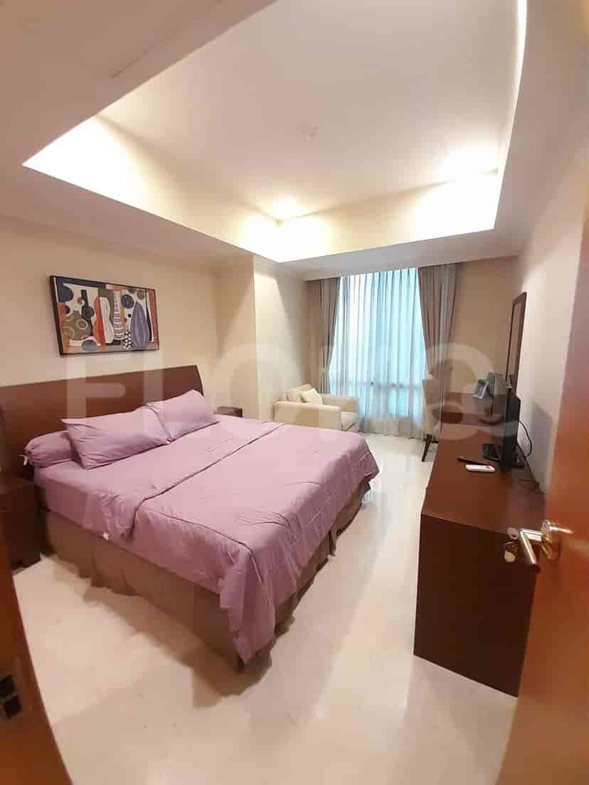 Bedroom with bed, side table, and art.