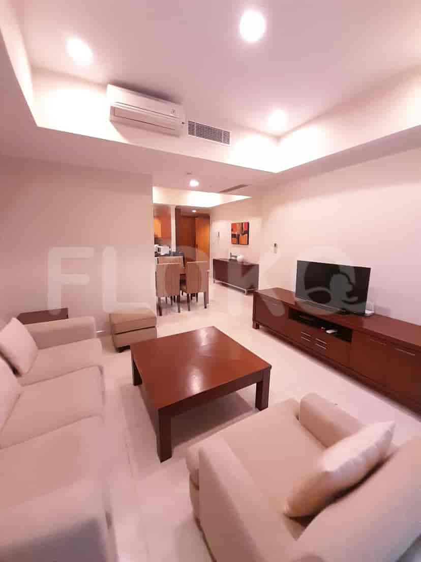 Living area with sofa, TV, and dining area in the background.