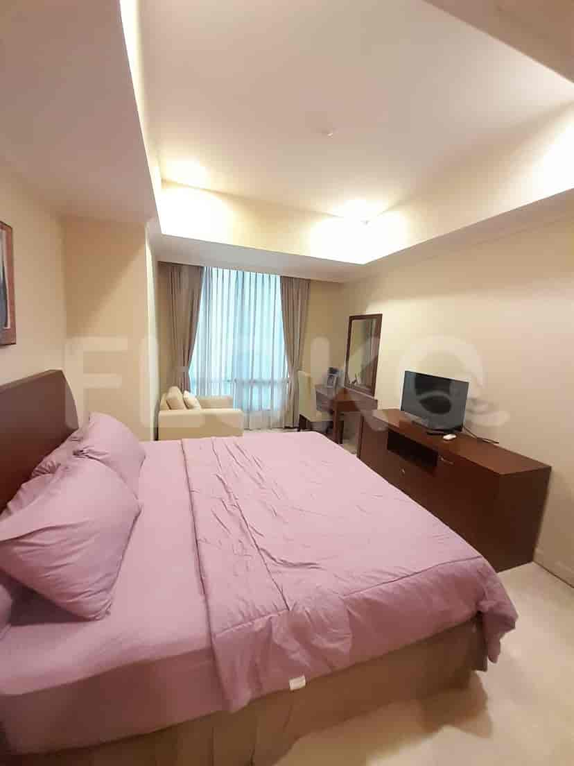 Bedroom with a large bed, desk, and a seating area.