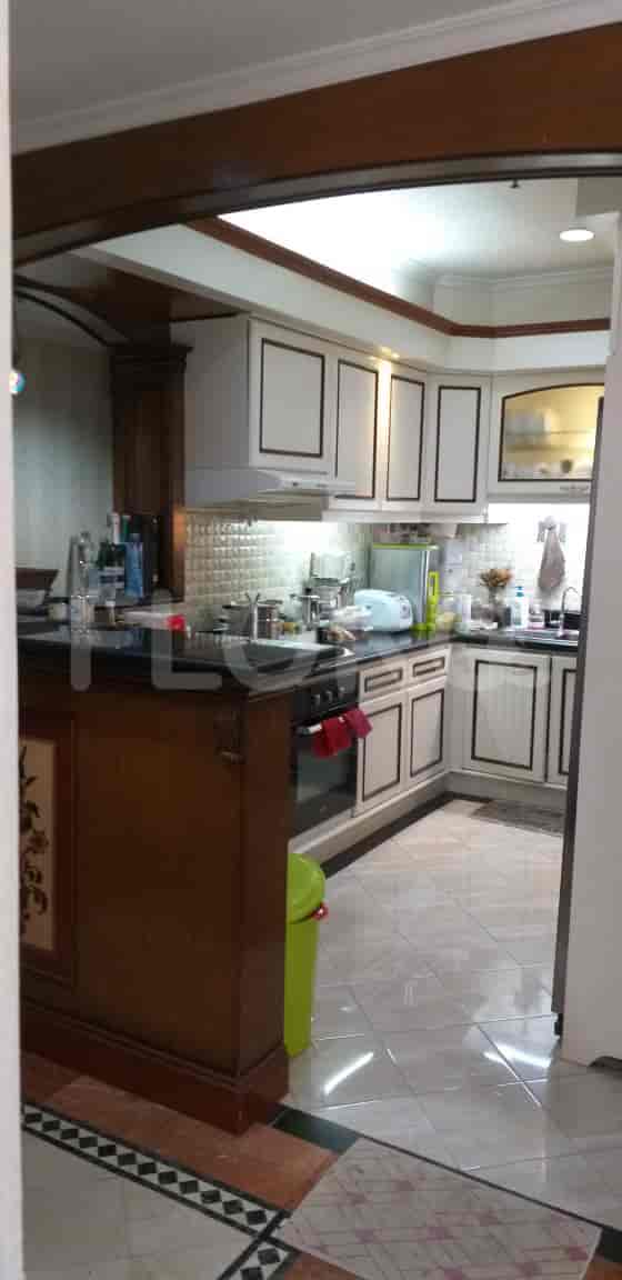 Well-lit kitchen with white cabinets, dark countertops, and tile flooring.