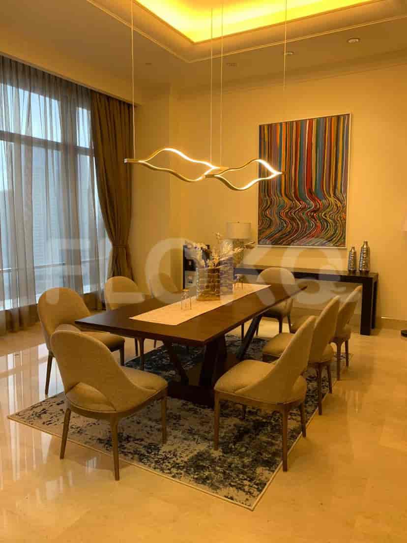 Elegant dining room with a wooden table, chairs, and a striking artwork.