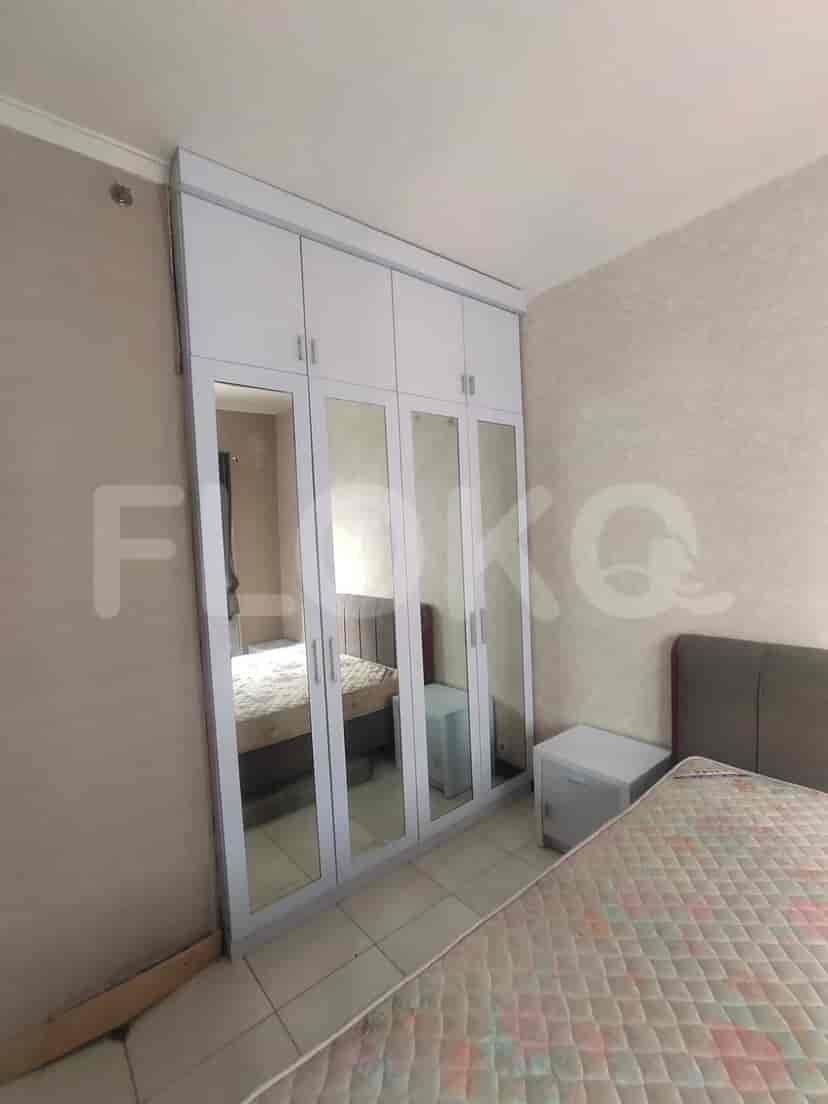Kamar tidur yang menampilkan lemari pakaian besar dengan pintu cermin dan tempat tidur ganda.