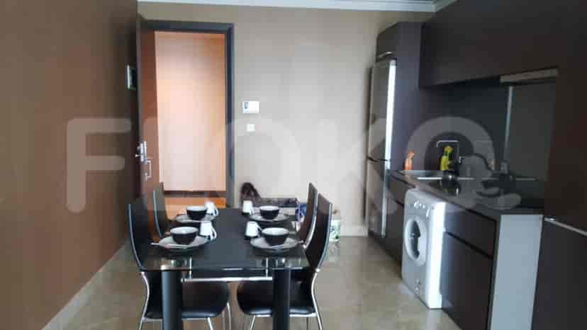 Dining area with a dining table and chairs, and kitchen with appliances.