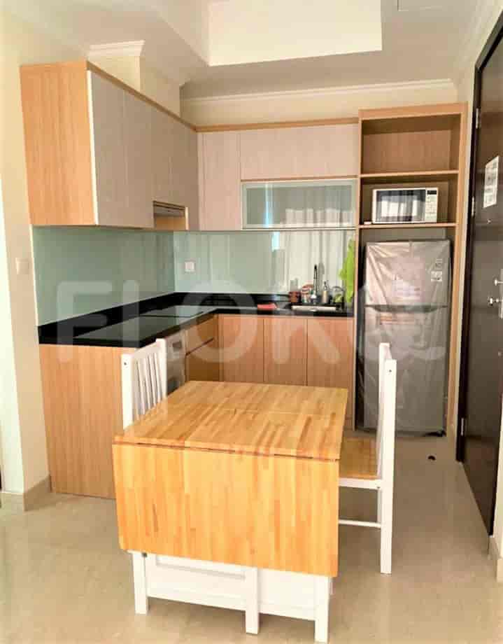 A compact kitchen with wooden cabinetry, a dining table, and essential appliances.