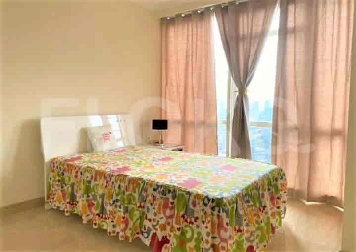 A bedroom with a bed, a colorful bedspread, a nightstand, and curtains.