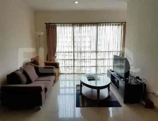 Another view of the living room with a sofa, TV, and a large window.