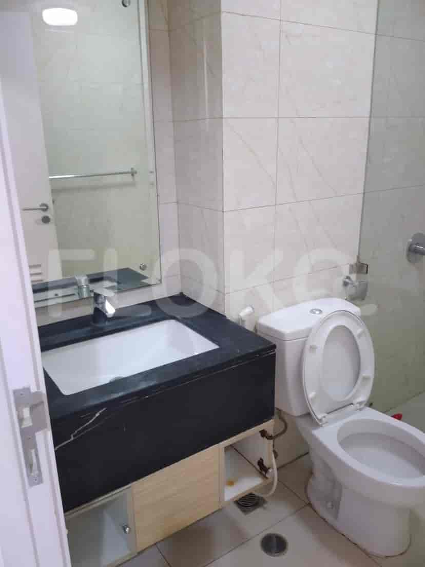 A modern bathroom with a sink, toilet, and marble tiles.