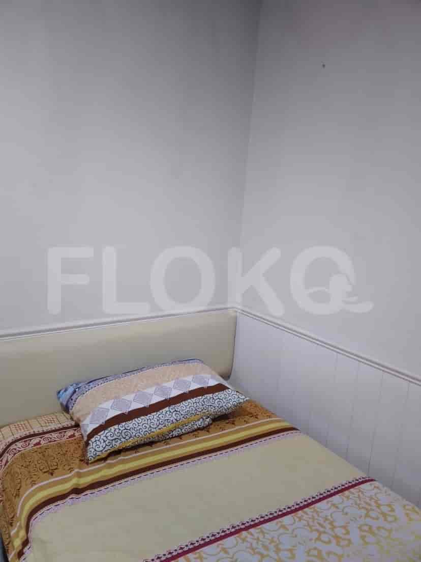 A bedroom with a single bed and a patterned pillow.